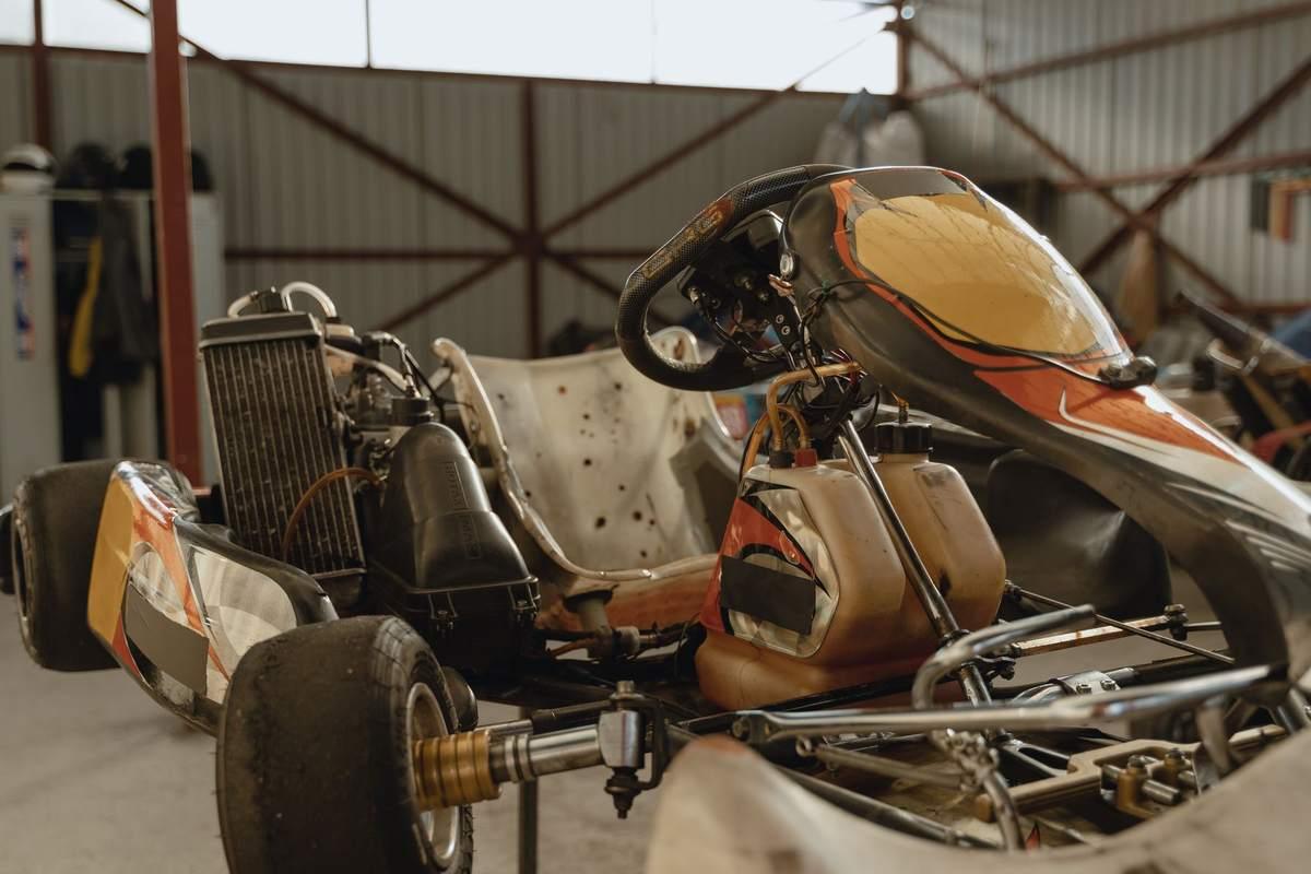 Kart jaune et noir dans un atelier avec outils et équipements de réparation mécanique visibles