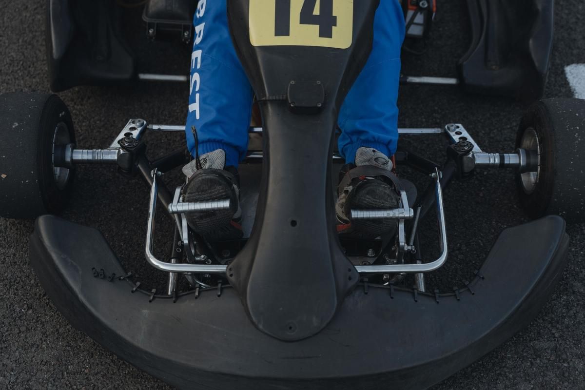 Pédales de frein d'un kart vues de dessus avec volant et numéro 14 visible