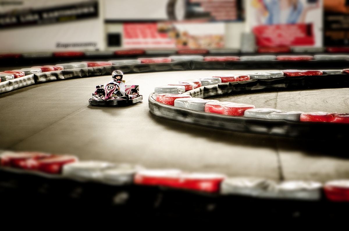 Un kart en virage sur une piste de karting intérieure Un kart en virage sur une piste de karting intérieure