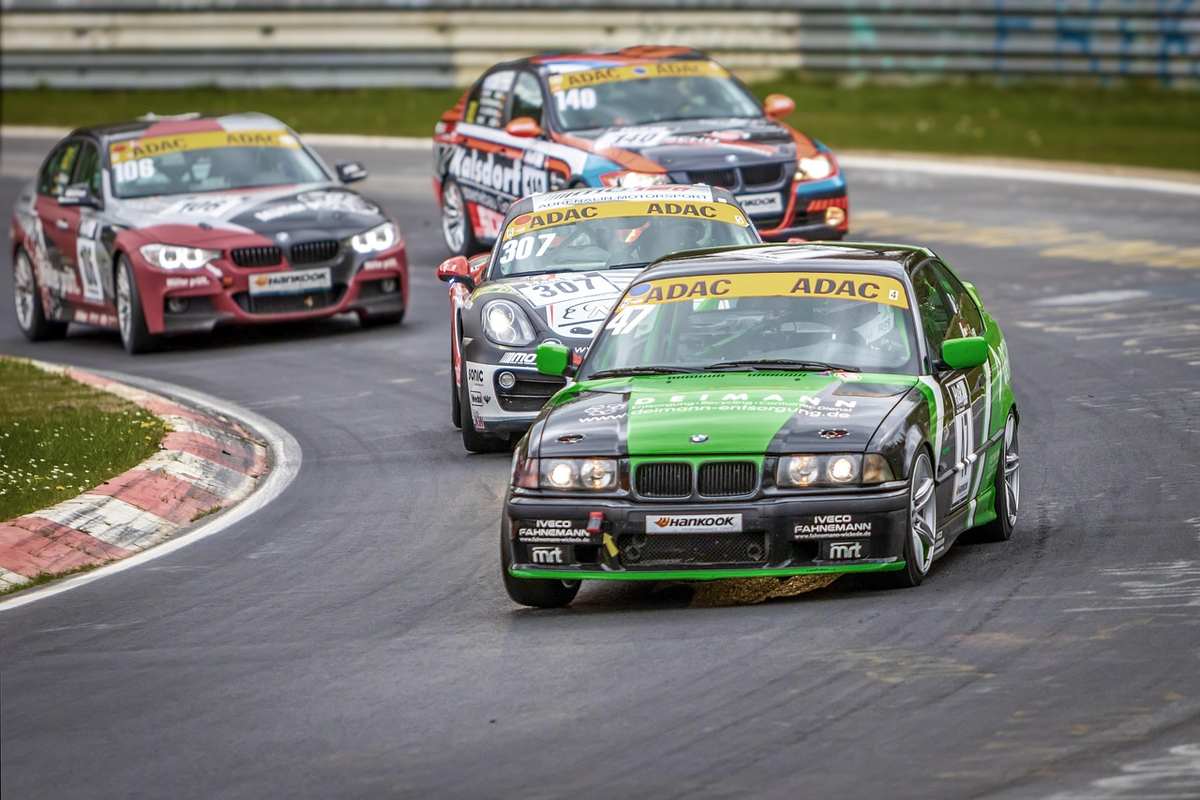 Plusieurs voitures de sport racing tournent en virage sur circuit Plusieurs voitures de sport racing tournent en virage sur circuit