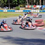 Plusieurs pilotes en kart sur une piste équipée de pneus de délimitation bleus