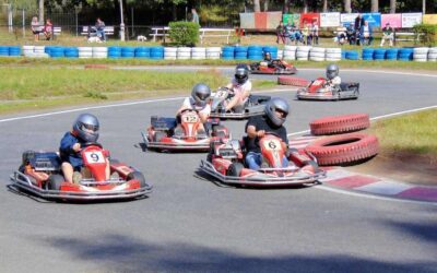 Plusieurs pilotes en kart sur une piste équipée de pneus de délimitation bleus