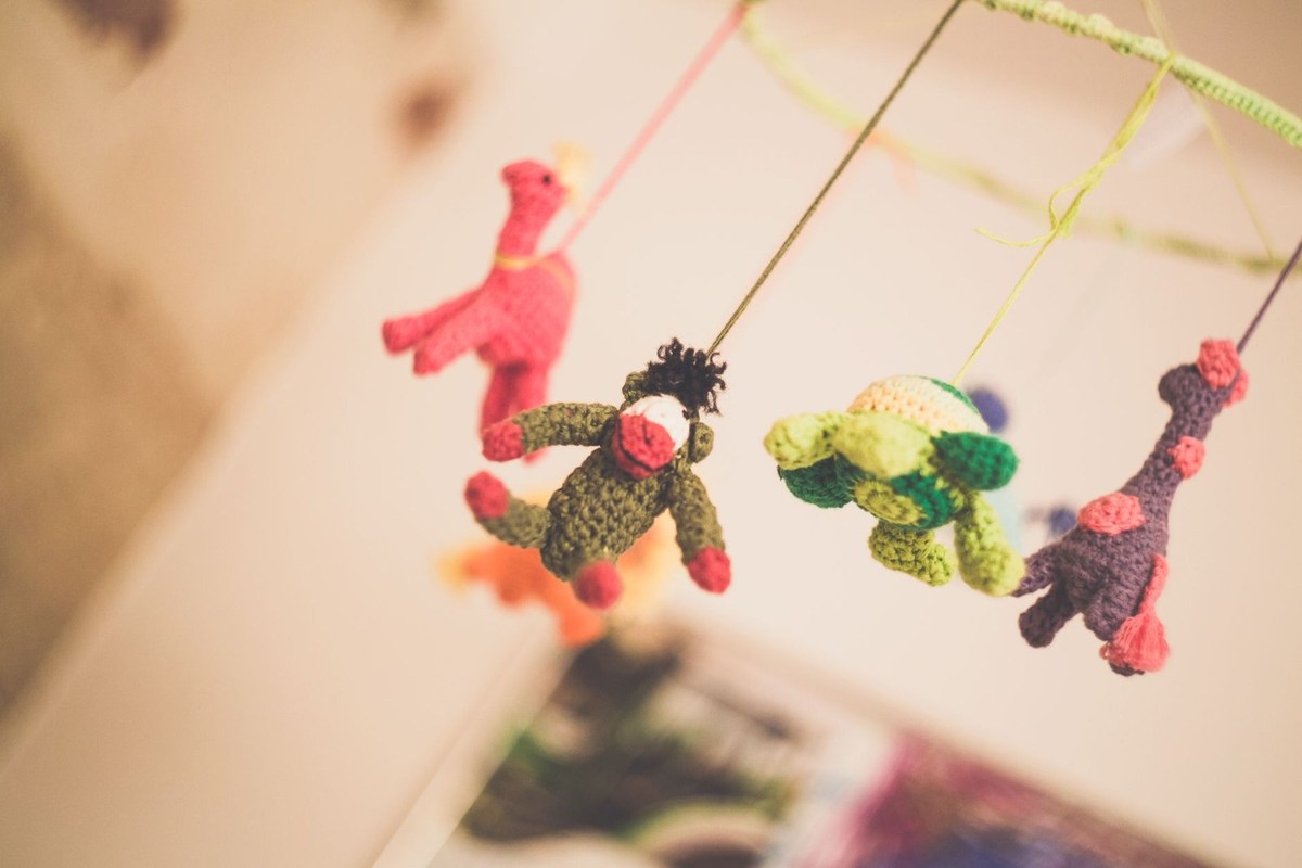 Jouets tricotés colorés suspendus à des fils, avec des animaux comme personnages