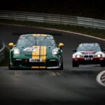 Voiture verte rayée jaune et voiture blanche rouge sur une piste de course