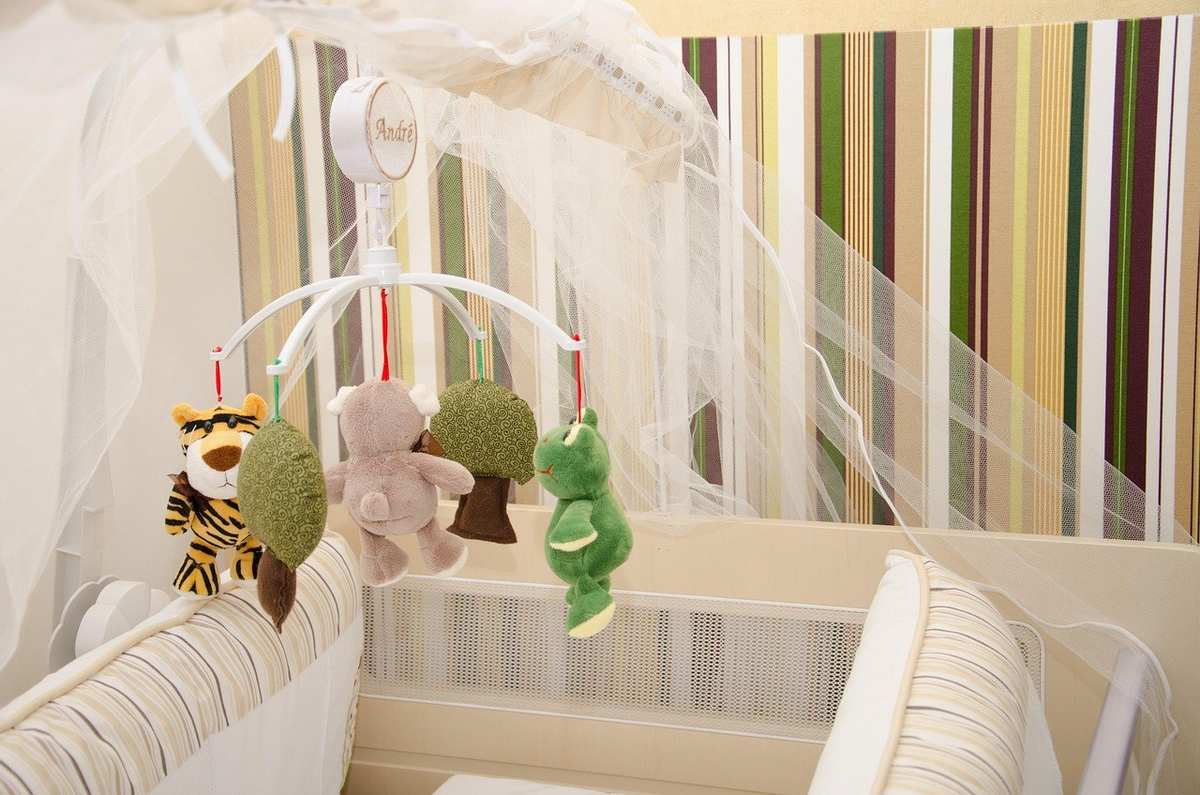 Berceau avec jouets suspendus et moustiquaire dans une chambre d'enfant