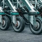 Plusieurs chariots métalliques alignés, leurs roues sur le béton