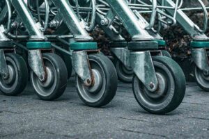 Plusieurs chariots métalliques alignés, leurs roues sur le béton