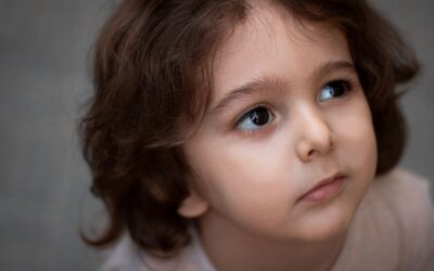 Un enfant aux cheveux bouclés regarde en haut, visage tourné légèrement