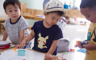 Enfants asiatiques manipulant des jouets sur une table dans une pièce lumineuse